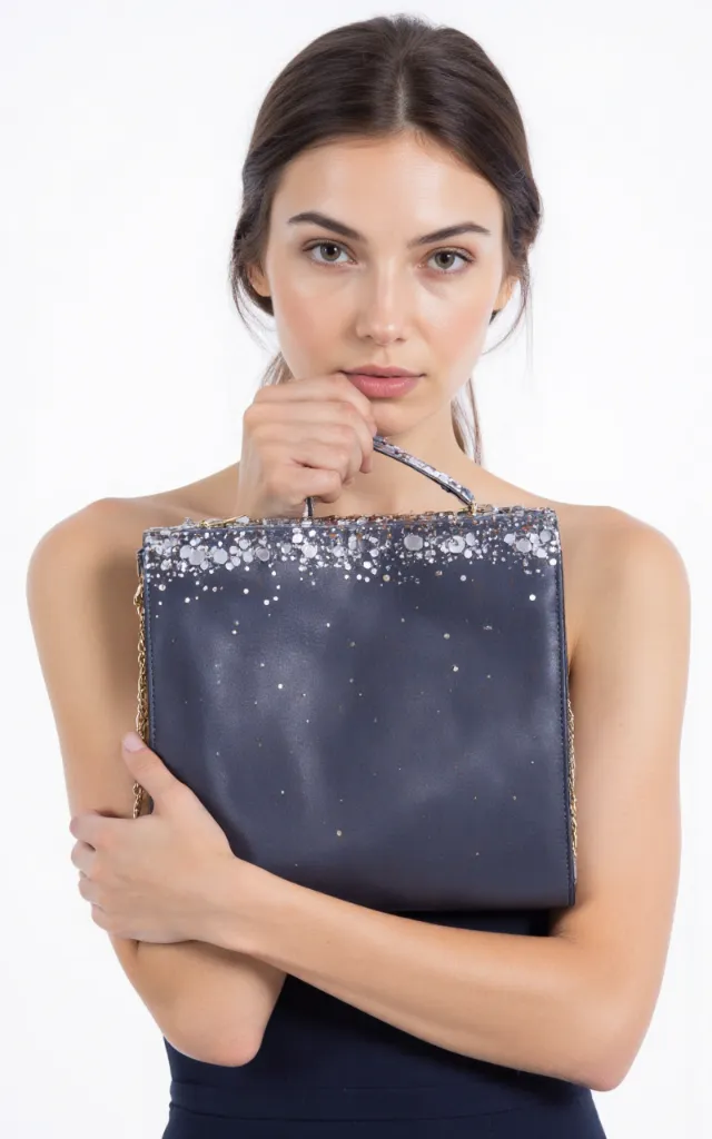 A French female model with a Party bag, wearing a dress, against a white background, in a front   facing close   up